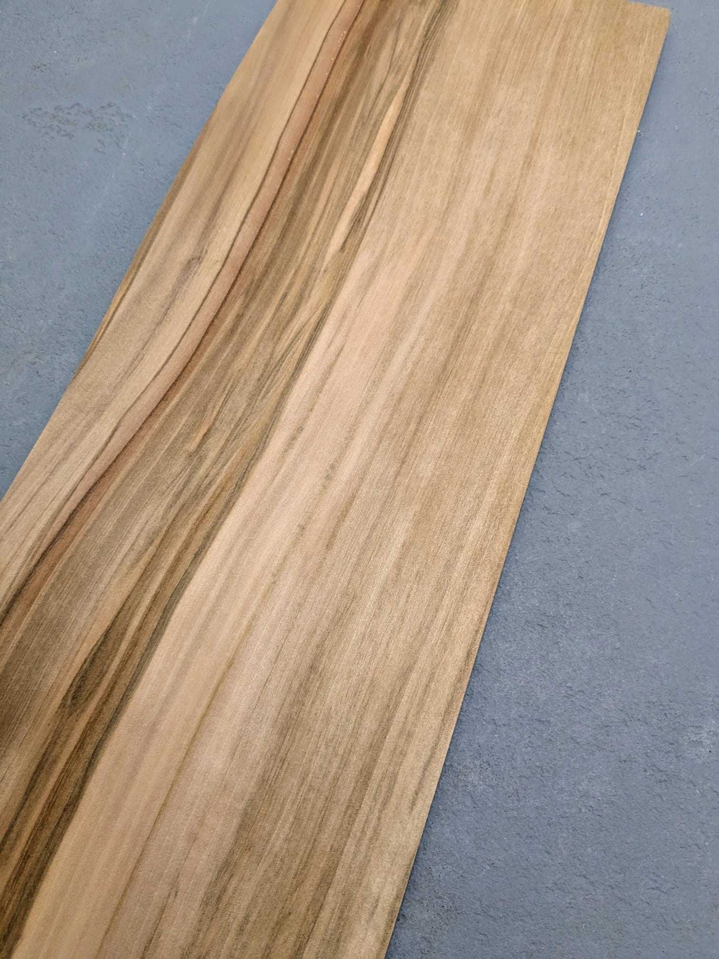 Los vel naturel Red gum houtfineer 50x20 cm op grijze ondergrond, onbehandeld fineer voor marqueterie of creatieve toepassingen.